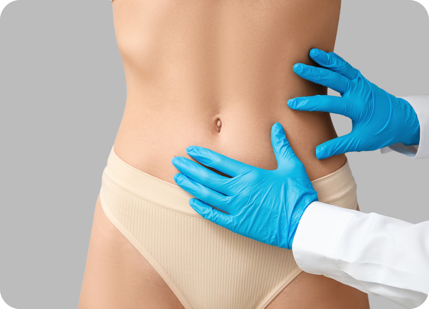 A imagem mostra o tronco e o abdômen de uma pessoa (provavelmente mulher) em um fundo cinza claro. A pessoa veste uma calcinha cor de pele/nude. Em primeiro plano, duas mãos calçadas com luvas médicas azuis, pertencentes a um profissional de saúde (cirurgião ou médico), tocam e examinam suavemente a região da cintura e abdômen. A imagem destaca um abdômen plano e contornado e representa um exame pós-cirúrgico, a avaliação dos resultados finais de um procedimento estético, como a abdominoplastia, ou a checagem da flacidez.